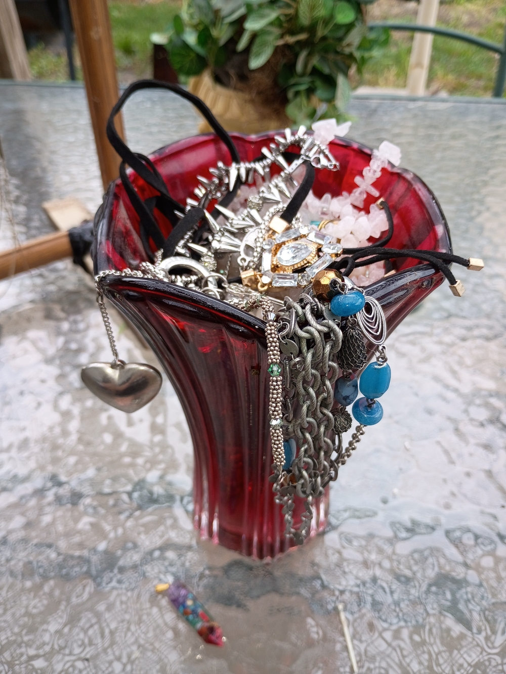 Red Glass Vase Filled with Assorted Jewelry
